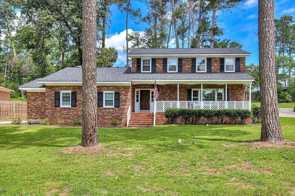 Welcome to your charming retreat! A classic brick exterior and lush green lawn greet you, perfect for arriving in style.