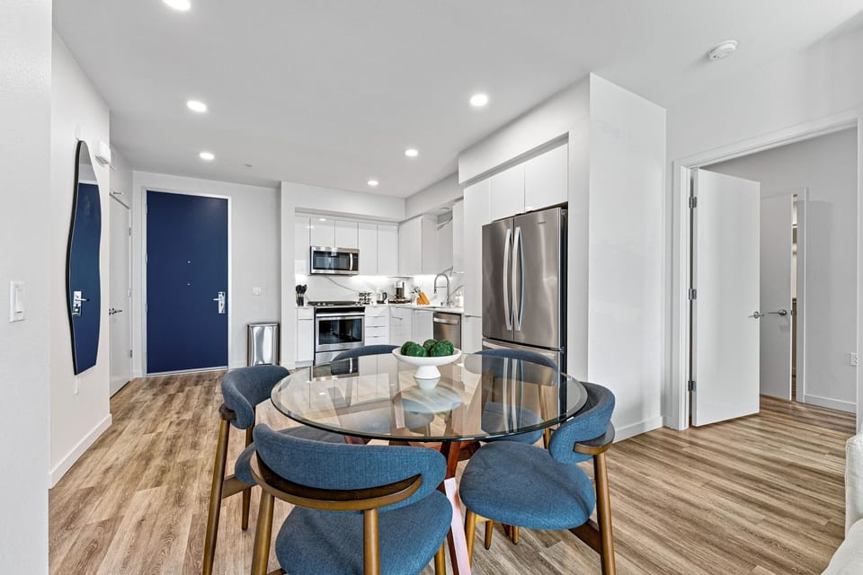 Stylish glass-top dining set perfectly situated near the modern kitchen.