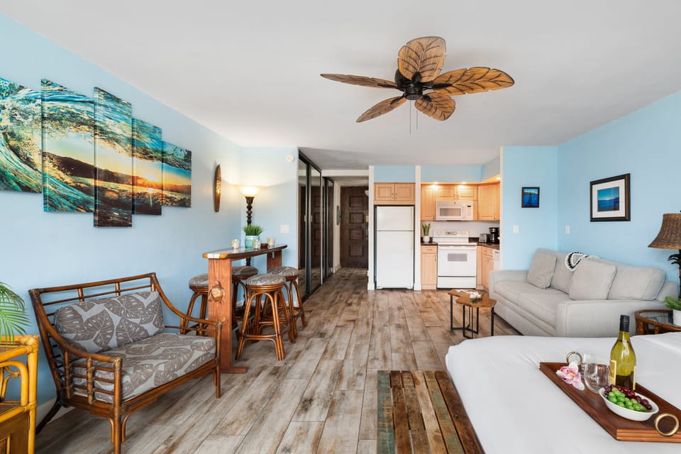 Open‑concept living and dining space with beach‑inspired décor, full kitchen, and ceiling fans for a breezy island stay.