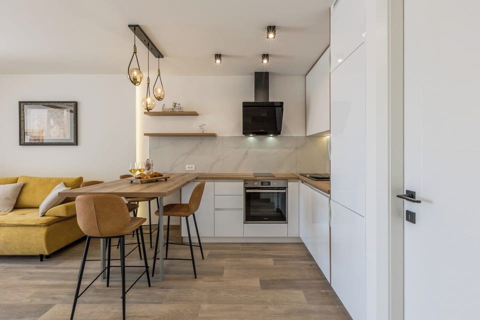 Elegant modern kitchen with dining area and warm, inviting tones.

