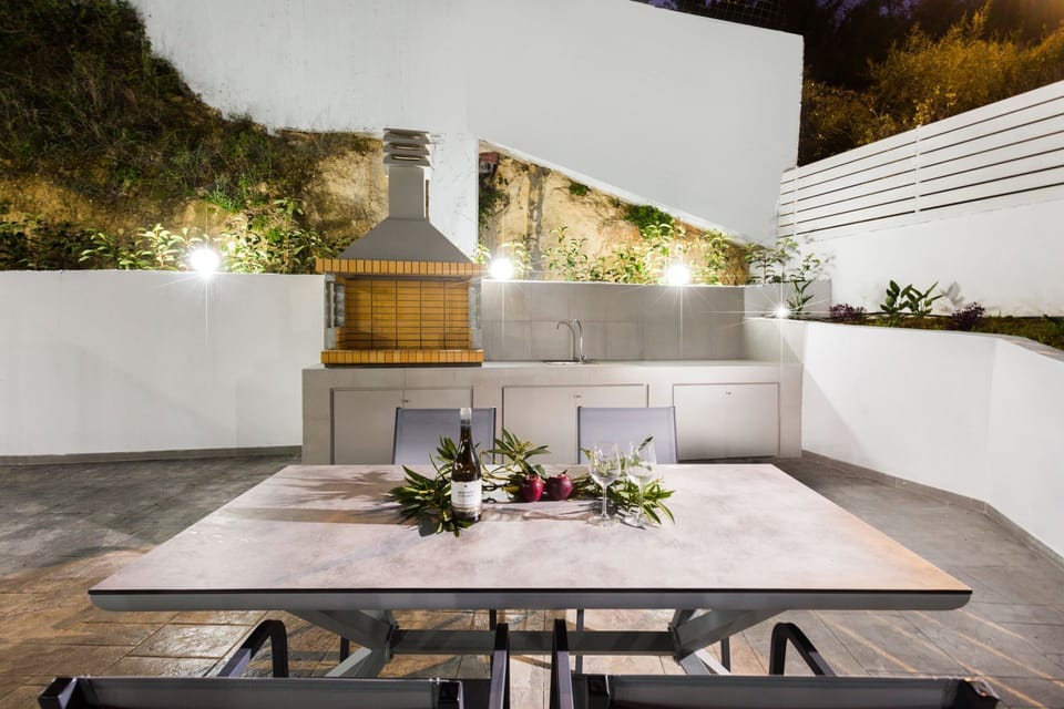 Comfortable outdoor dining and seating area with BBQ next to the pool