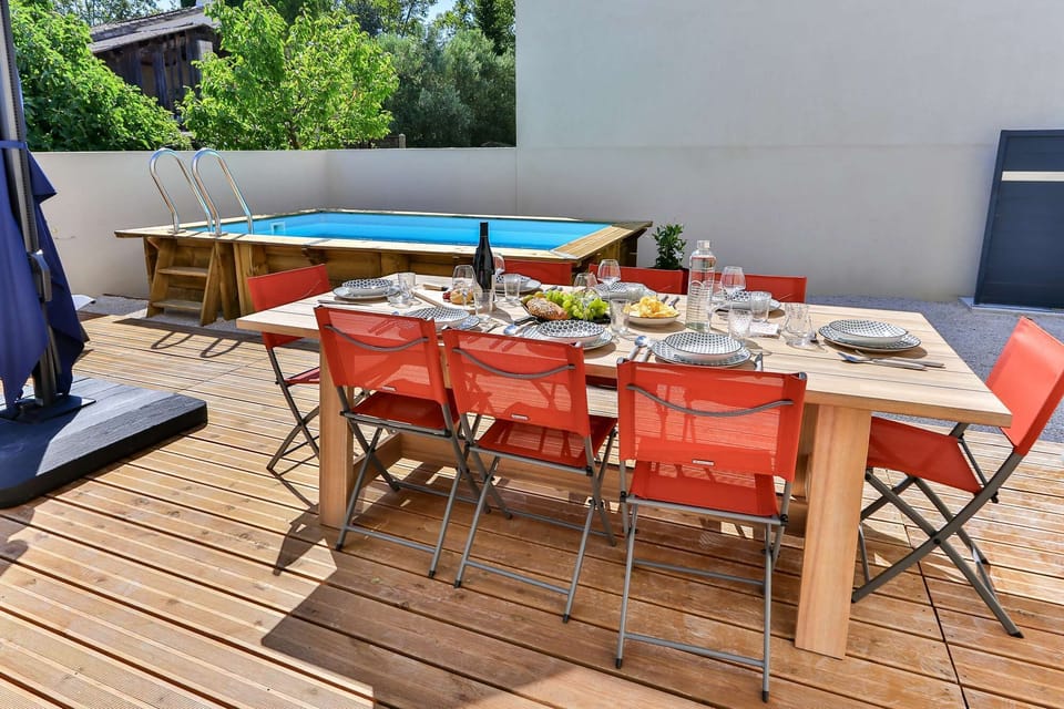 Grande table extérieure pour partager des repas conviviaux avec vue sur la piscine