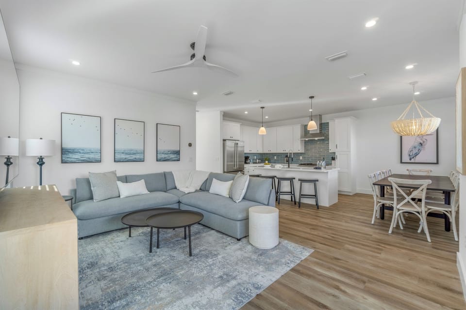 1st Floor - Spacious living room with plush seating and a large Smart TV, designed for large groups to relax together after the beach
