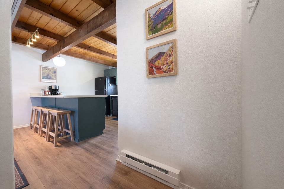 Cozy beam-ceiling kitchen with island seating and coffee bar.