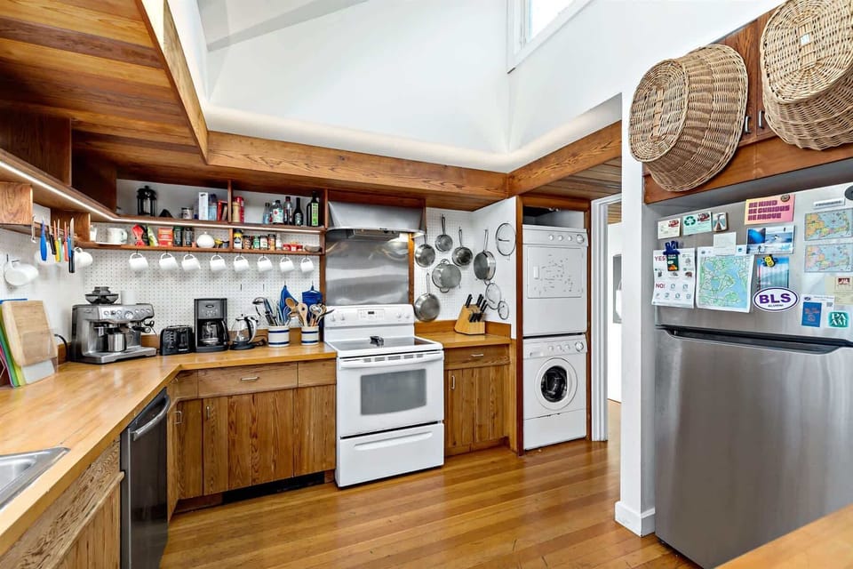 Cook with ease in the main kitchen, featuring a full range, cookware storage, and laundry tucked nearby for convenience.