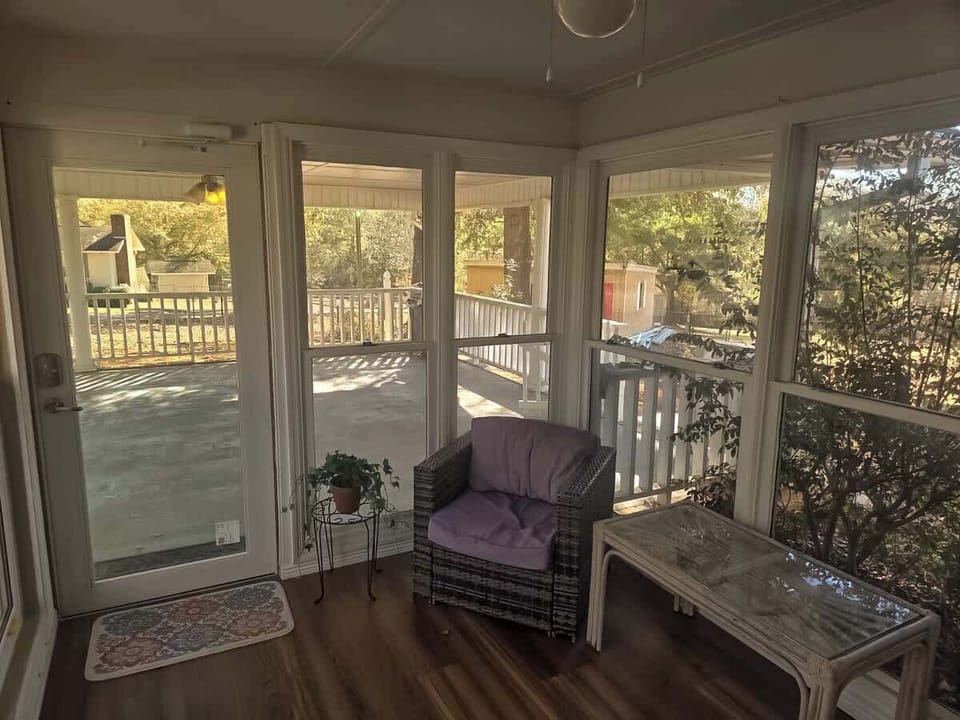 Bright and peaceful sunroom with large windows and glass doors that let in plenty of natural light. A cozy spot to relax, enjoy your morning coffee, or unwind while taking in the surrounding views.