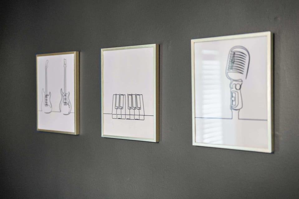 Minimalist music-inspired art lines the hallway, a subtle nod to the soul that fills this house from room to room.