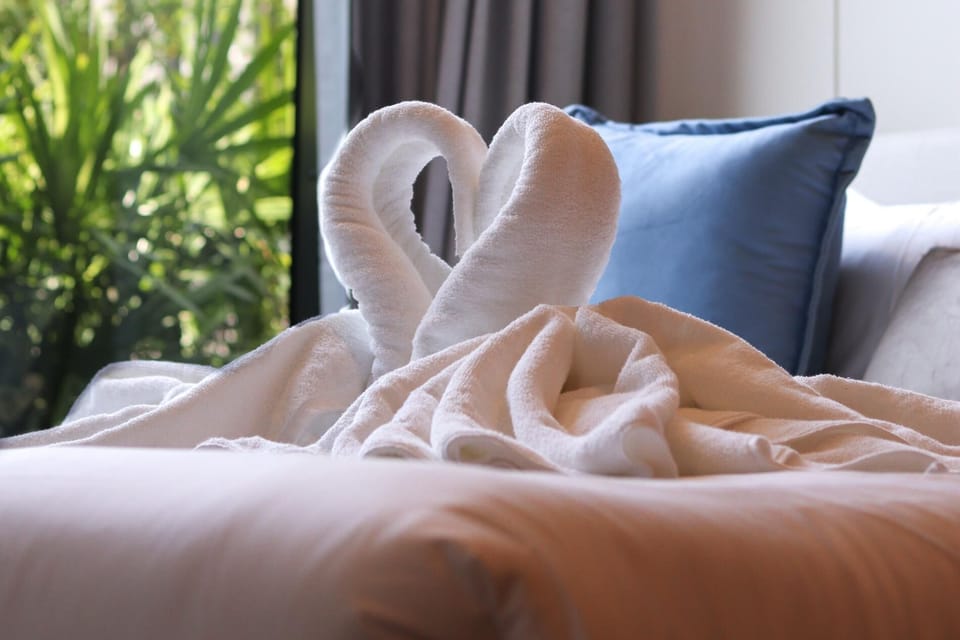Fresh towels arranged in a decorative heart shape for a warm guest welcome.