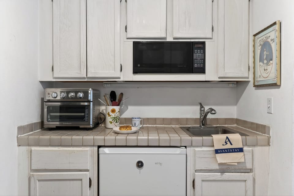 Kitchenette with microwave, toaster oven, and mini refrigerator.