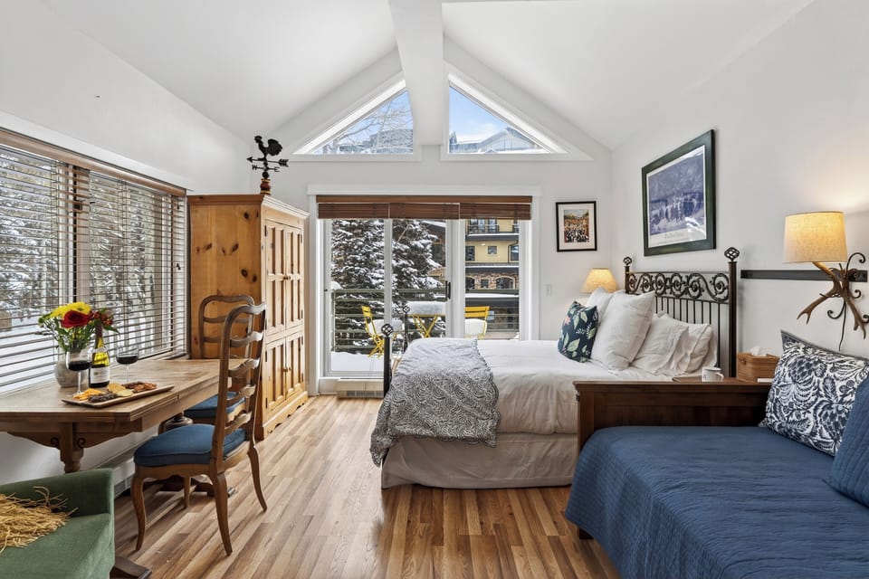 Spacious studio showcasing the open layout, wood flooring, and large picture windows.