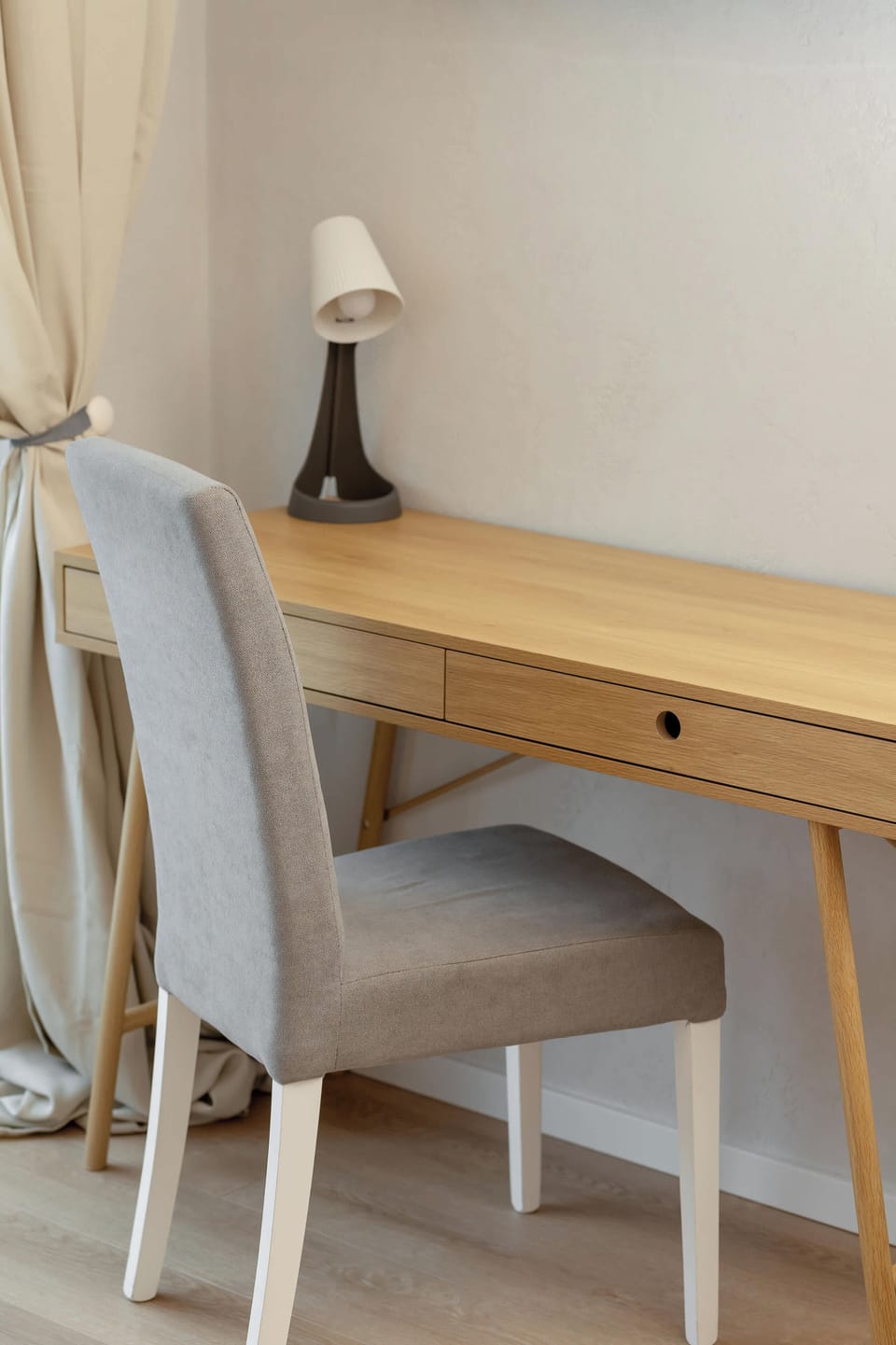 A wooden desk with a chair provides a comfortable place to work.