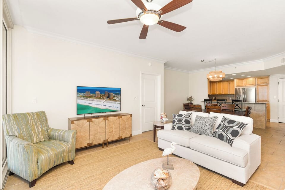 Unwind in your spacious living room where coastal breezes flow through, with comfortable seating and modern entertainment for your perfect getaway.