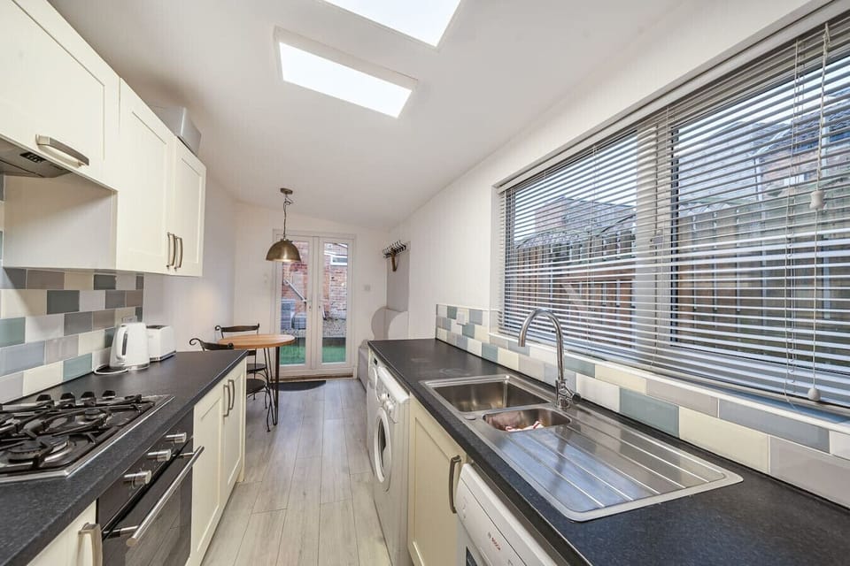 Cook and prep along the long worktop with a large window above the sink.