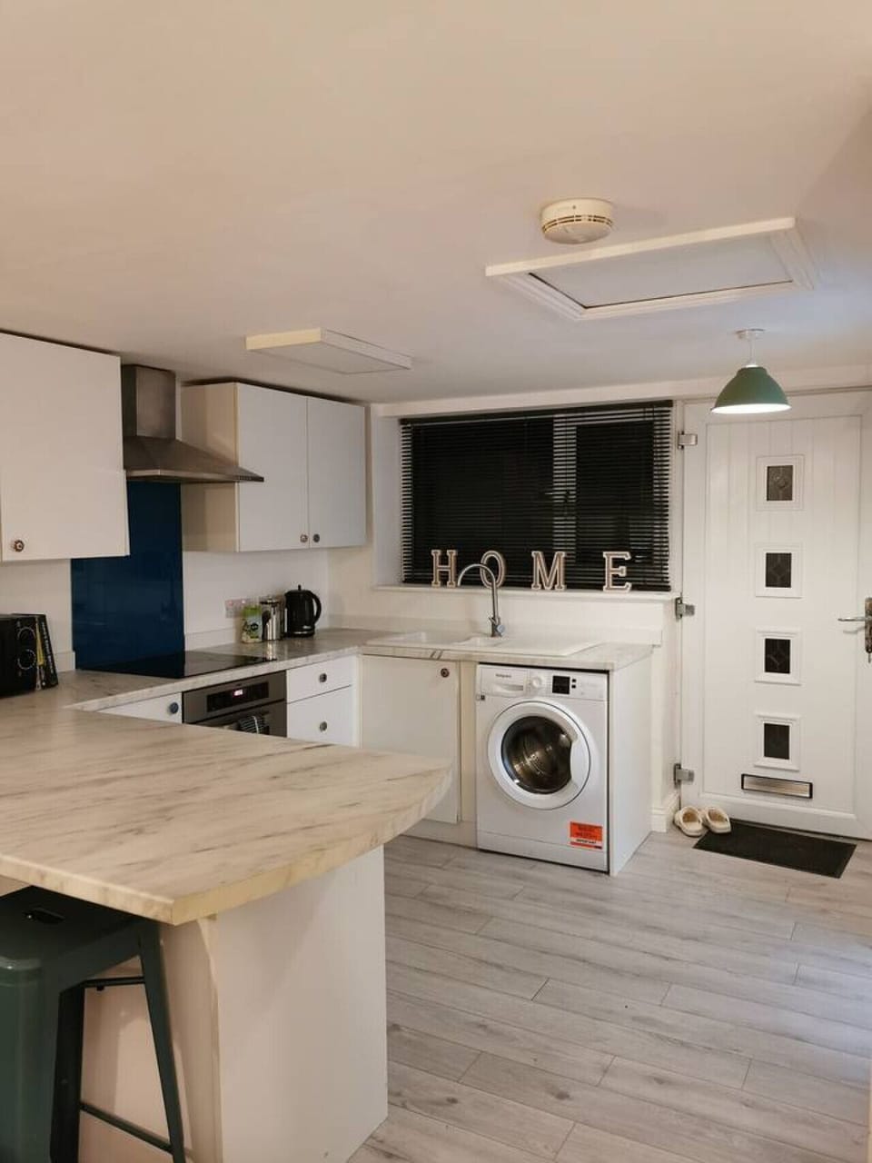 Prepare meals in the open-plan kitchen with a breakfast bar and washing machine.