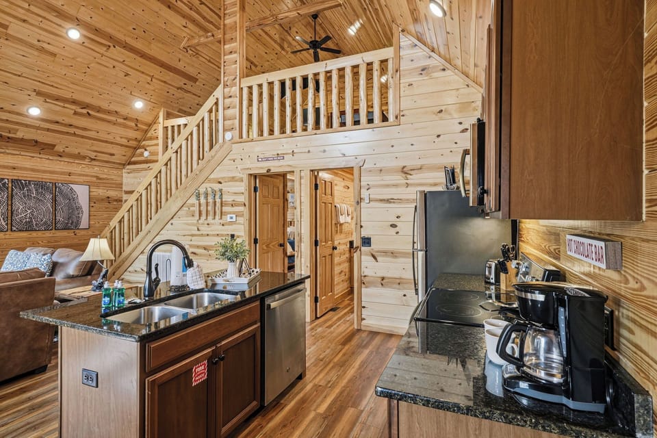 Step into your open-concept cabin retreat, where soaring ceilings, warm wood tones, and a cozy loft create the perfect mountain getaway. Your fully equipped kitchen awaits your morning coffee ritual.