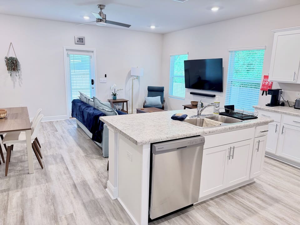 Bright open-concept kitchen and living space with island and TV
