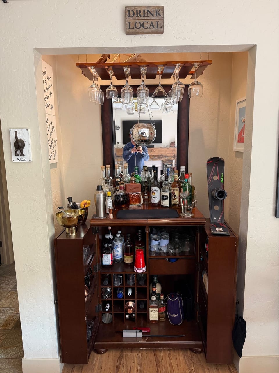 Cozy built-in bar with wine cubbies, stemware rack, and mirrored flair