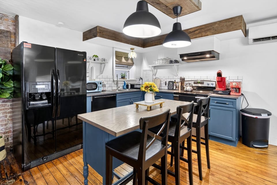 Blue kitchen with a breakfast island and prep space.