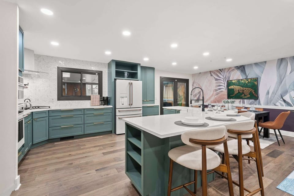 Modern kitchen w/ large island, barstool seating & sleek cabinetry for easy group meals.