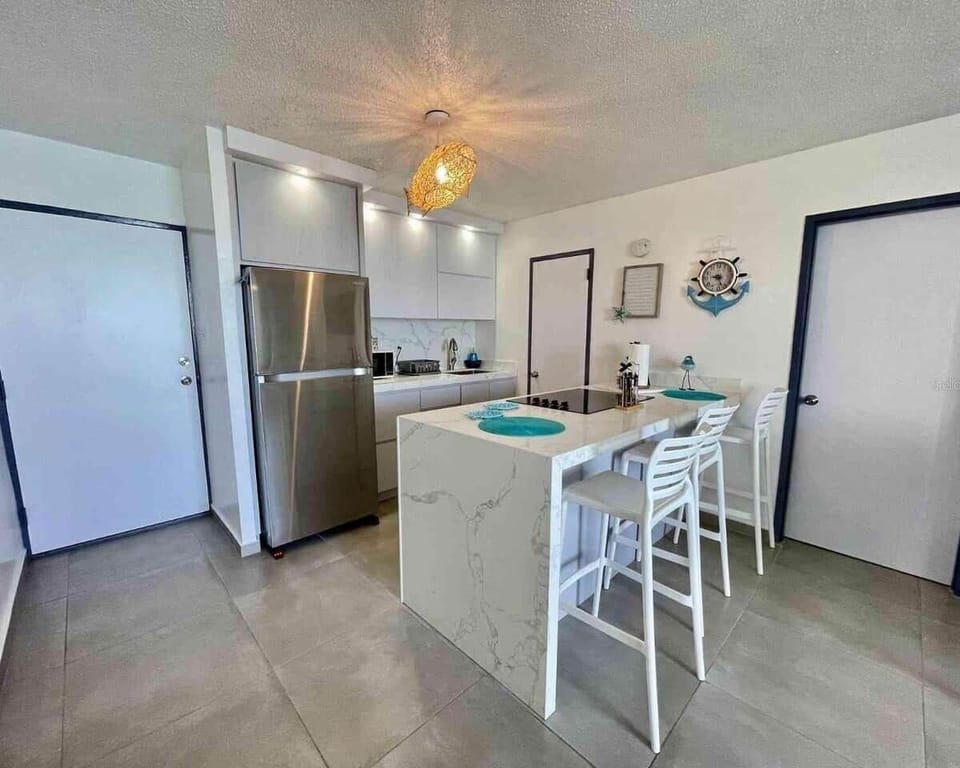 Fully equipped kitchen with modern appliances, spacious island and seating for meals