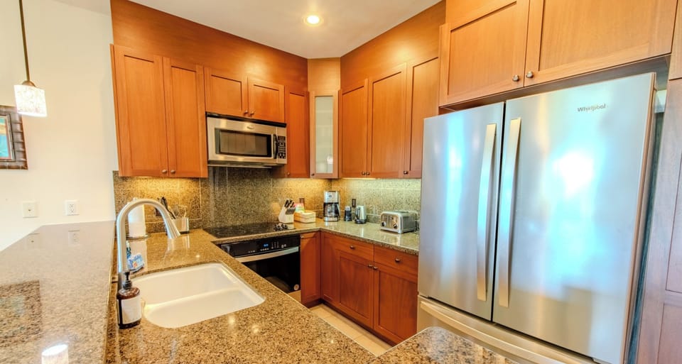 Cook effortlessly in a granite kitchen with stainless appliances.
