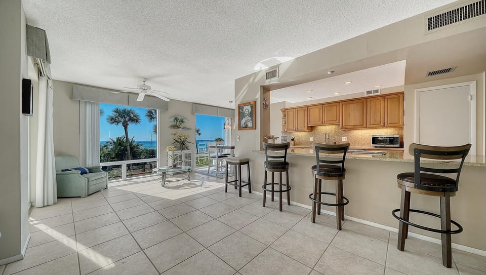 Sunlit living room with ocean views and open kitchen bar seating