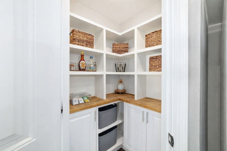 Enjoy this custom pantry featuring open shelving, labeled baskets, and ample storage for all your cooking essentials. With plenty of space to keep groceries tidy and easy to access, this pantry adds both function and charm to your stay.