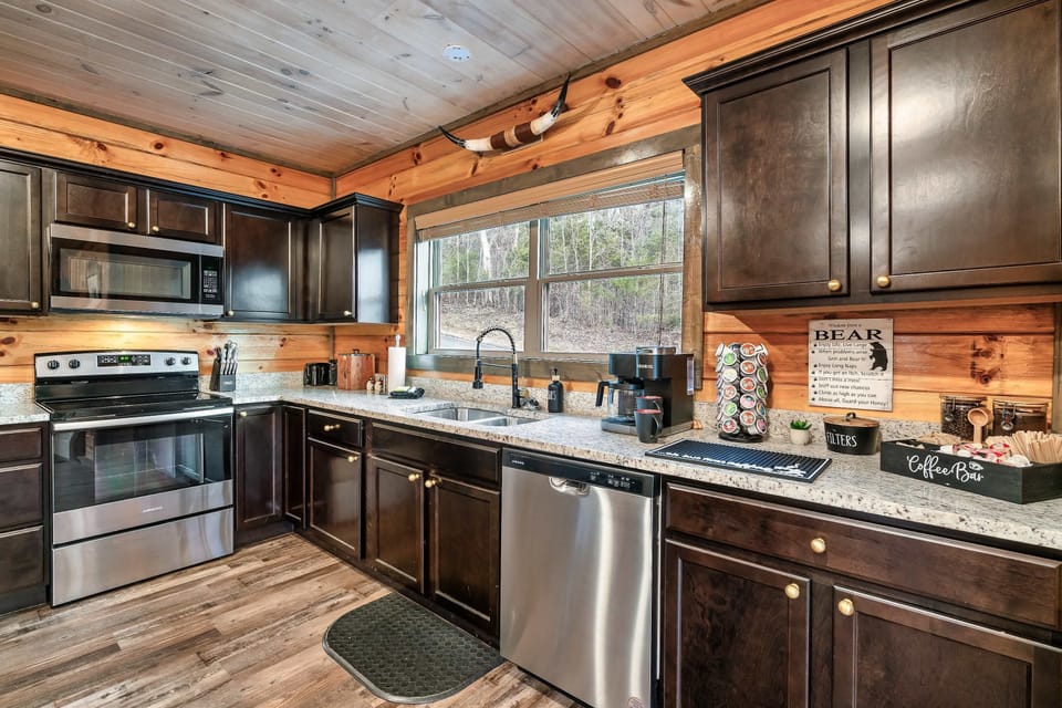Fully equipped kitchen with stainless steel refrigerator, oven, microwave, and dishwasher.