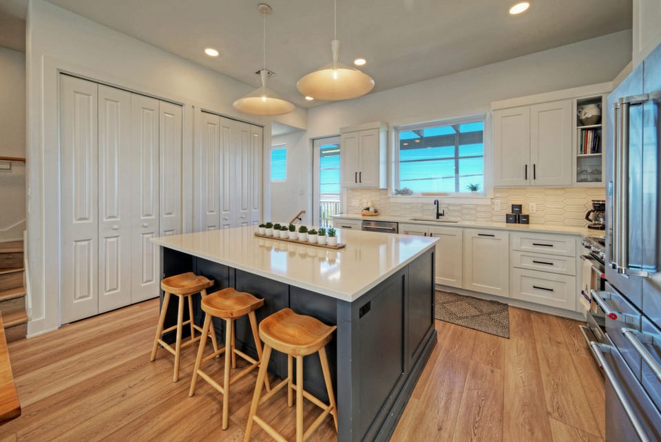 Fully equipped kitchen with large island, barstool seating, and reliable equipment.