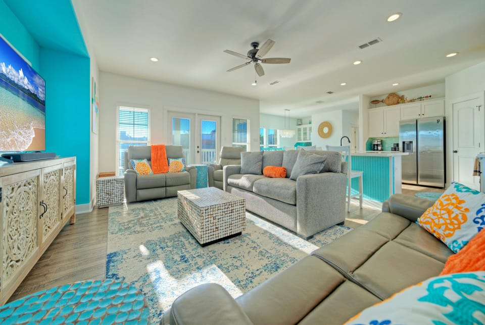 Bright, open-concept living space with coastal décor, plush seating, and easy flow into the kitchen—perfect for relaxing after a day in Port A.