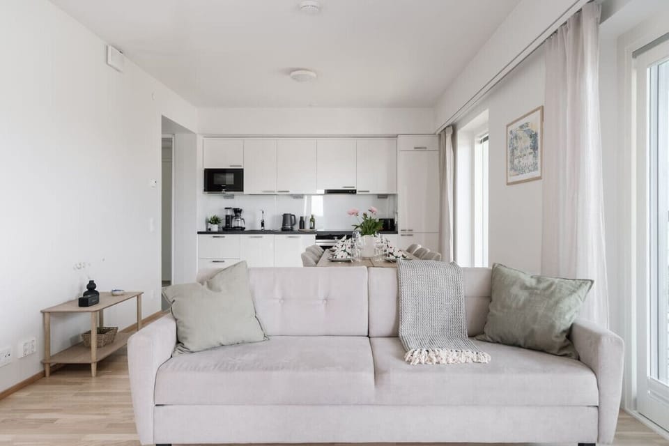 Bright open-plan living and kitchen area with a cozy, inviting couch for relaxation.