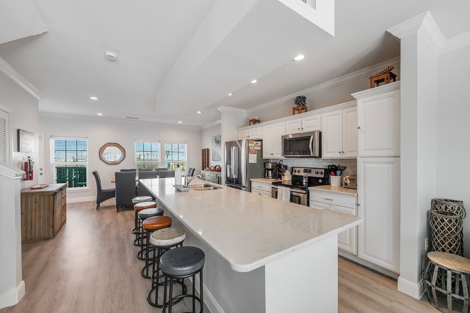 Your gourmet kitchen features pristine white cabinets, quartz countertops, and stainless steel appliances, creating the perfect space for culinary adventures.