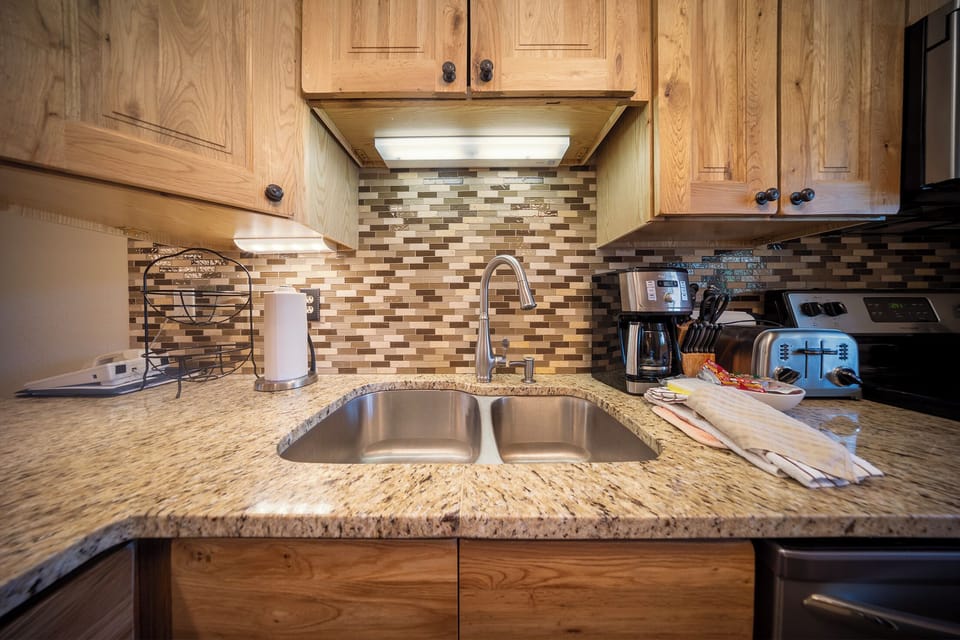 Your fully equipped kitchen awaits with granite counters, stainless appliances, and warm wood cabinets—perfect for preparing meals together.