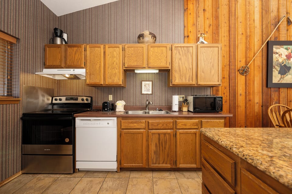 Your fully equipped kitchen features warm wood cabinetry, granite counters, and everything you need to prepare meals during your stay.