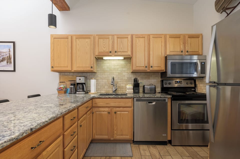 Your fully equipped kitchen features granite counters, stainless appliances, and warm wood cabinets—perfect for preparing meals during your stay.
