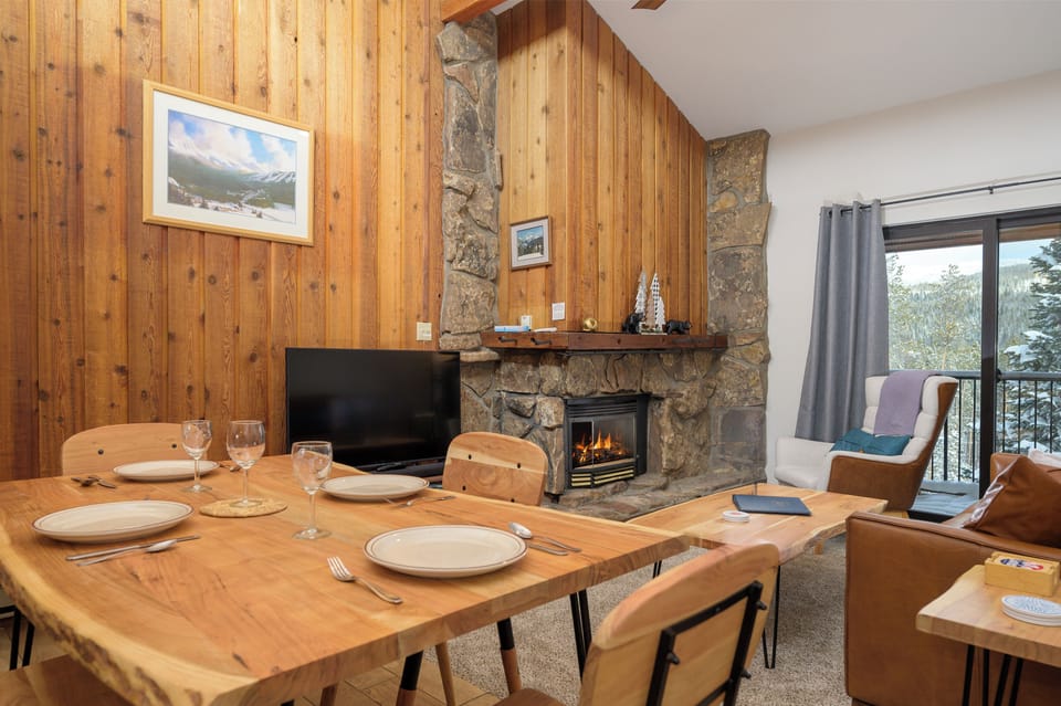 Warm wood-paneled dining room with stone fireplace where you'll share memorable meals with mountain views beyond.