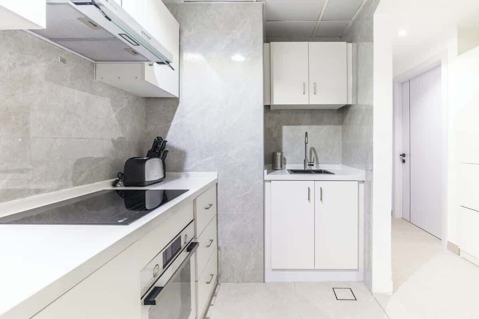 A complete kitchen setup featuring a sink, storage space, and elegant countertops for preparing meals.