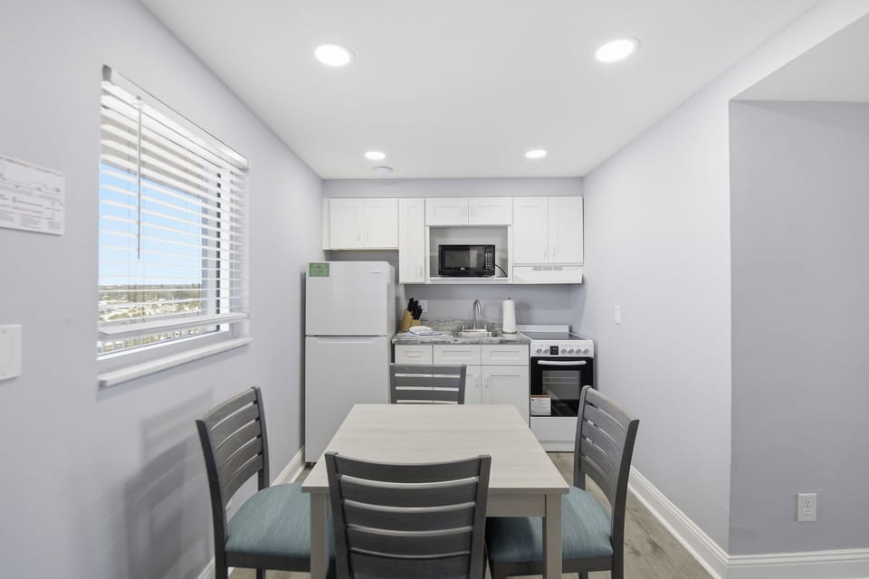 This well-equipped kitchen includes modern appliances and a dining table, inviting culinary adventures and cozy meals with a lovely view.