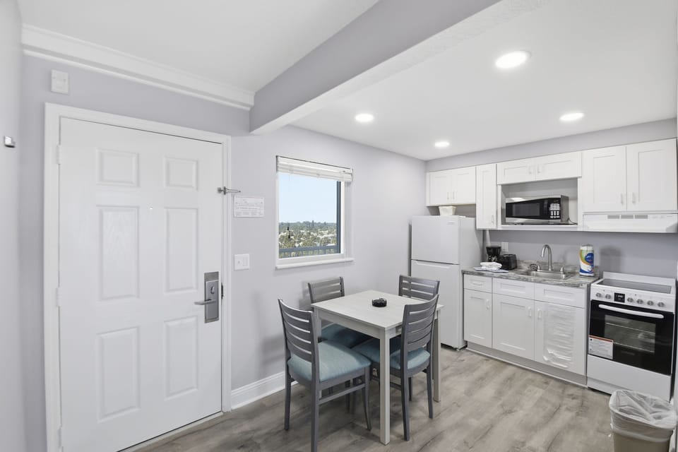 A well-equipped kitchen boasts modern appliances and a dining table, perfect for enjoying home-cooked meals while overlooking scenic views through the window.