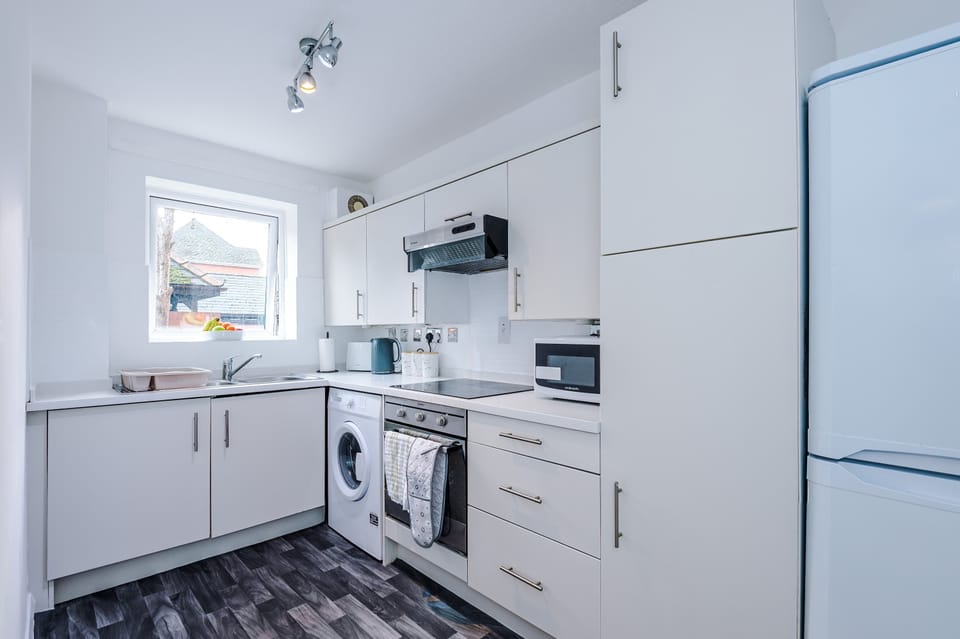 Modern Kitchen: Bright, fully-equipped space with stylish appliances and fruit-filled window view!