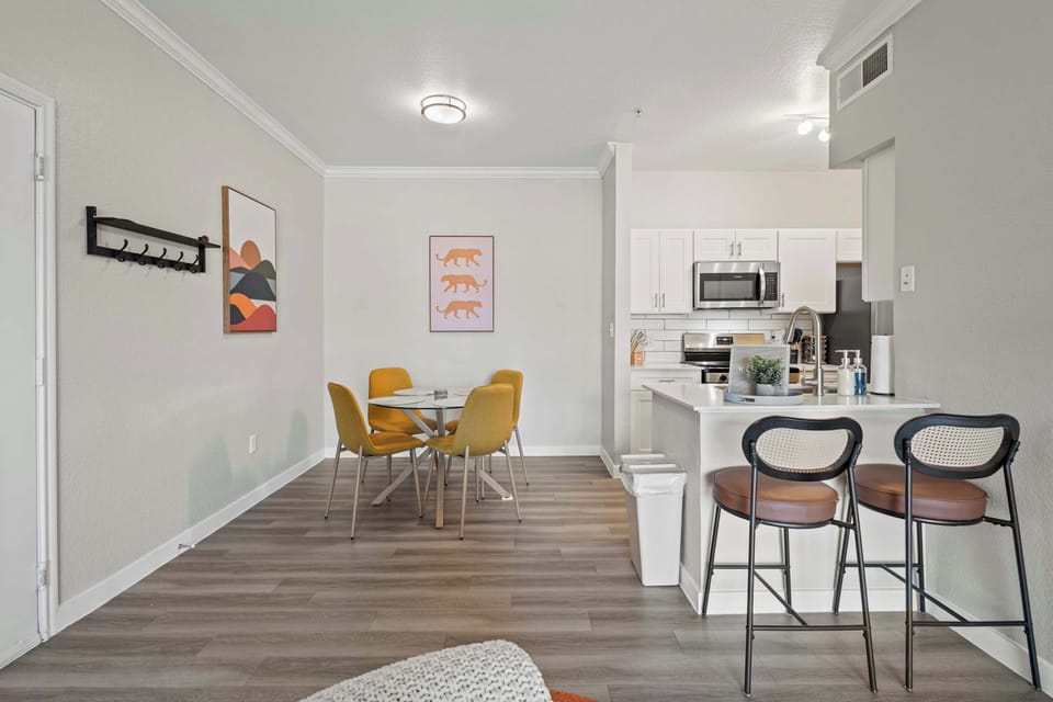Modern dining area with stylish seating and an open view of the kitchen. This bright and functional space is perfect for shared meals, casual work, or enjoying takeout while staying connected with the rest of the living area.