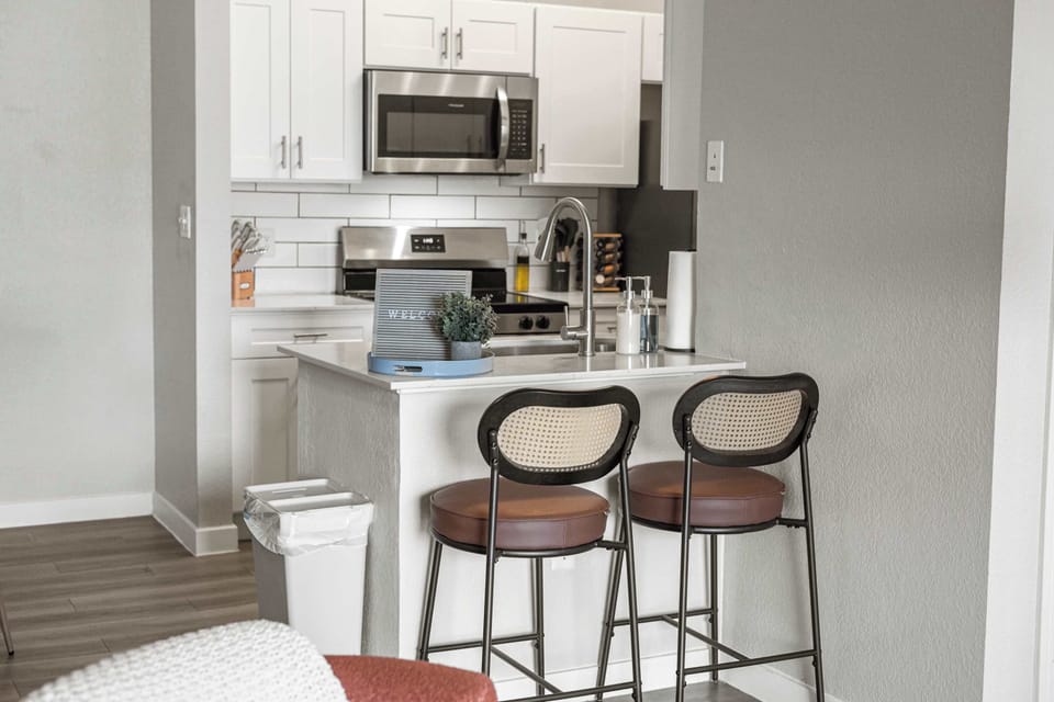 Convenient kitchen bar seating with modern stools provides a casual spot for meals, morning coffee, or conversation. The open layout keeps the space connected, making it easy to enjoy time together while cooking.
