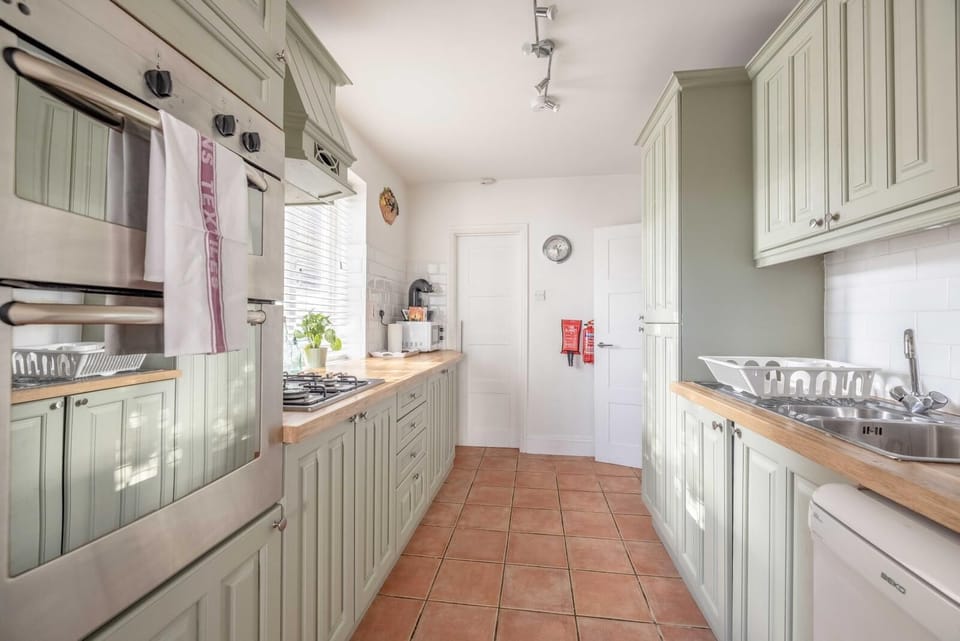 Kitchen: Whip up culinary delights in this bright, airy kitchen with stylish green cabinetry!