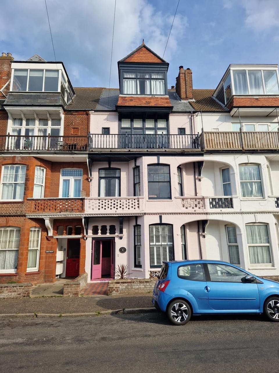 Charming Exterior: Vibrant seaside retreat with unique character and inviting balconies.