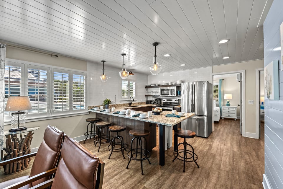 The living area leads into the clean, modern kitchen with sleek appliances.