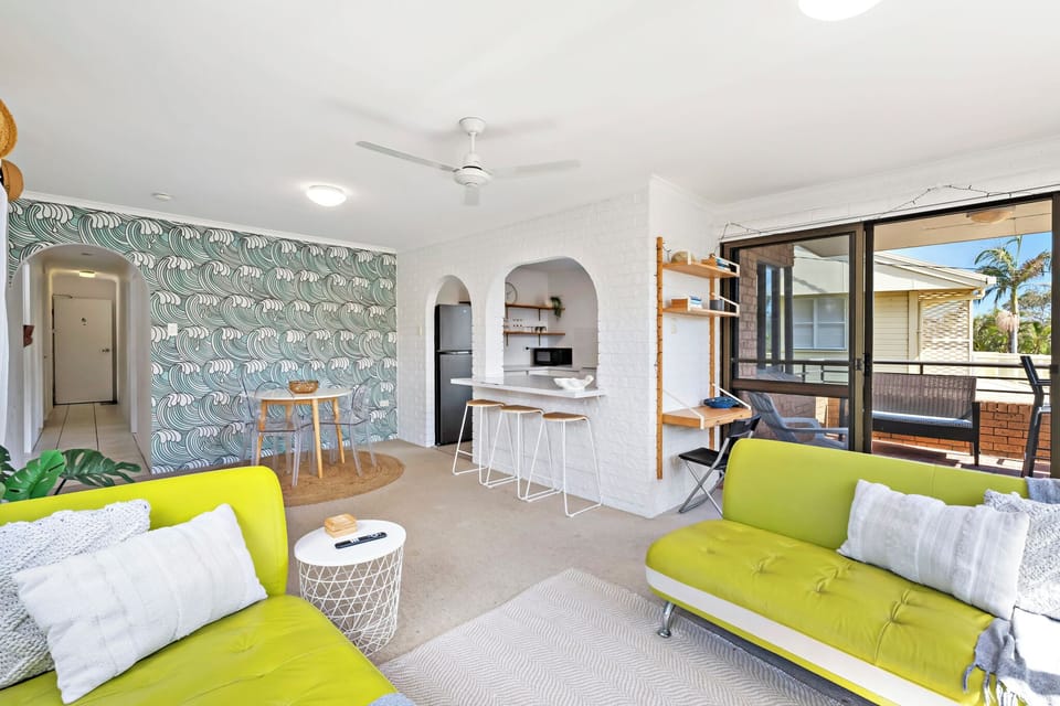 Bright living room with 2 sofas, ceiling fan, Smart TV, and beach views.
