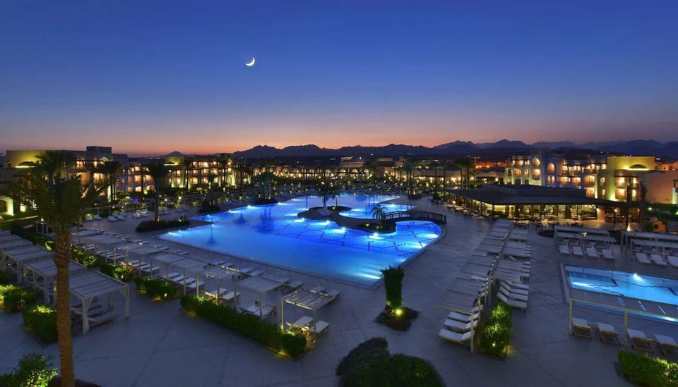 Unwind at dusk as the glowing pool lights set the mood.