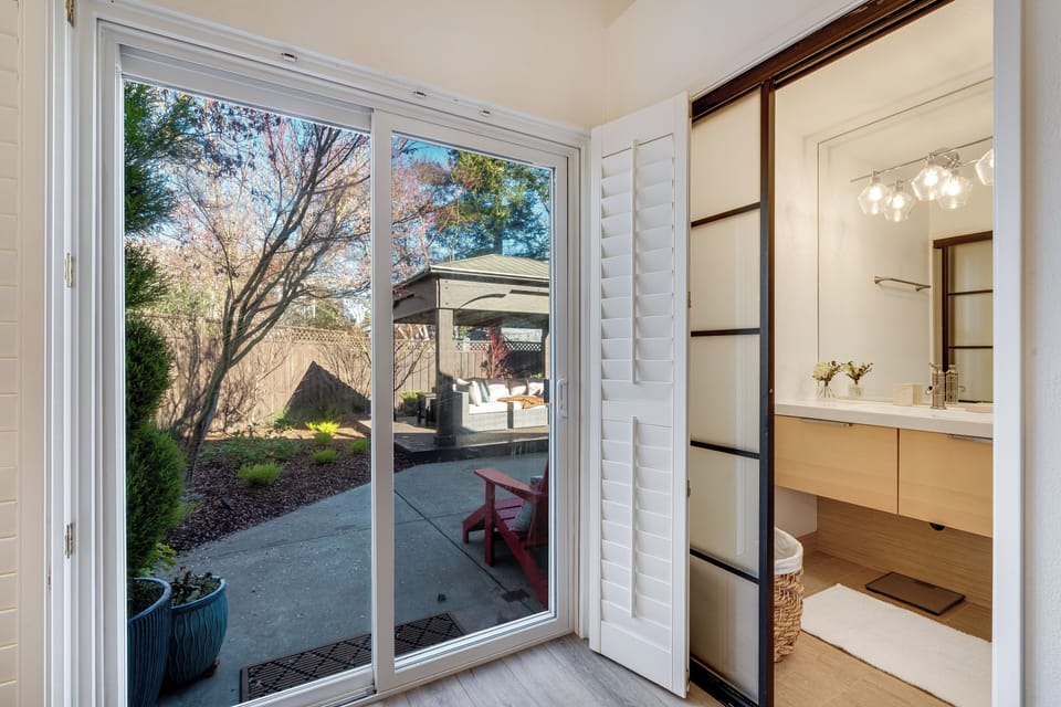 Your private bathroom flows seamlessly to the serene backyard, where natural light highlights elegant fixtures and peaceful garden views.