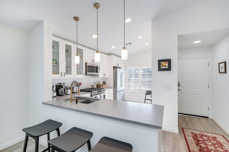 Cook together in this bright, modern kitchen with sleek granite counters, stainless appliances, and pendant lighting creating the perfect culinary experience.
