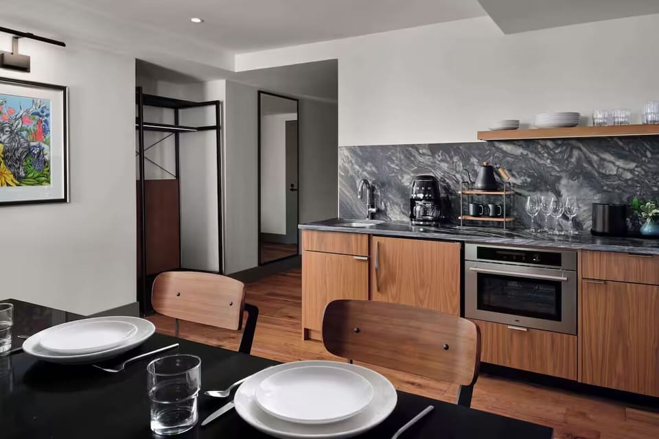Cook and sip coffee in a modern kitchen with stone backsplash.